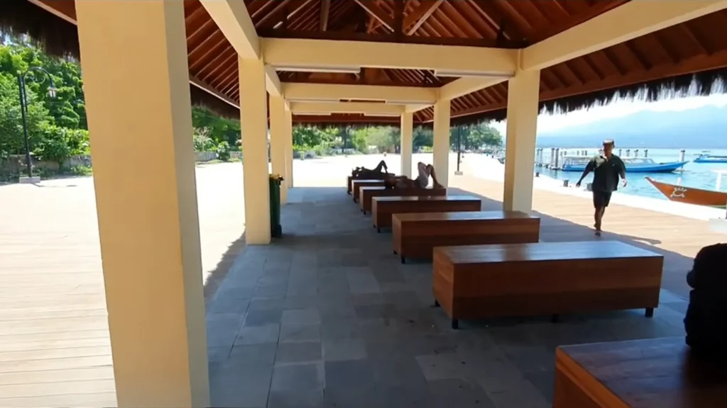Passenger waiting area within Gili Air Port Facilities with seating and shade near the pier.